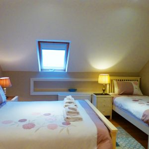 Ein Doppelbett und ein Einzelbett im Schlafzimmer fünf auf der ersten Etage von Ferienhaus Castle View in Glenbeigh in Kerry, Irland.