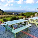 Patio with two Picnic Tables at Holiday Home Castle View in Glenbeigh, County Kerry, Irland.